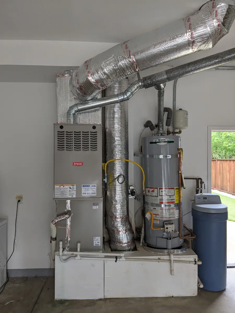 A gas furnace and water heater in a garage.