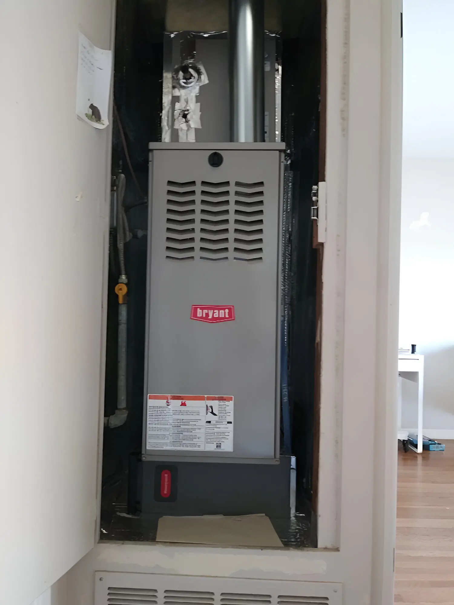 A gas furnace is in the corner of a room.